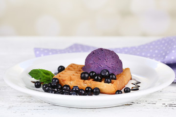 Tasty belgian waffles with ice cream on wooden table