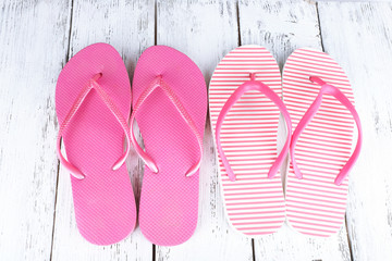 Colorful flip-flops on wooden background