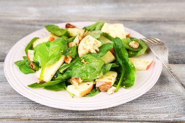 Green salad with apples, walnuts and cheese on wooden