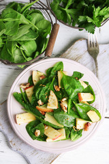 Green salad with apples, walnuts and cheese on wooden