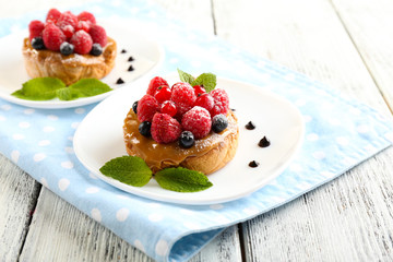 Sweet cakes with berries on table close-up