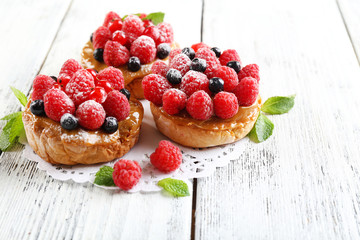 Sweet cakes with berries on table close-up