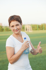 sports woman  50 years with a  bottle of water, outdoors
