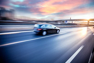 Photo sur Plexiglas Voitures rapides Voiture roulant sur autoroute au coucher du soleil, flou de mouvement