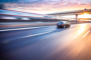 Auto rijden op de snelweg bij zonsondergang, bewegingsonscherpte
