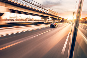 Obraz na płótnie Canvas Car driving on freeway at sunset, motion blur