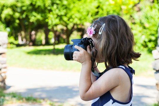Little girl who takes pictures in park