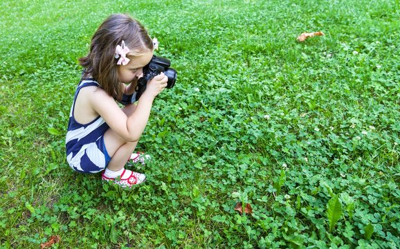 Girl who takes pictures with a photo camera in park