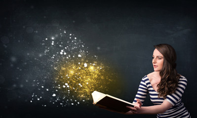 Young lady reading a magical book