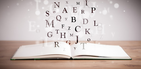Opened book with flying letters