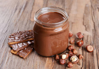 Sweet chocolate cream in jar on table close-up