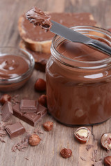 Sweet chocolate cream in jar on table close-up