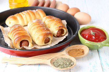 Baked sausage rolls in pan on table close-up