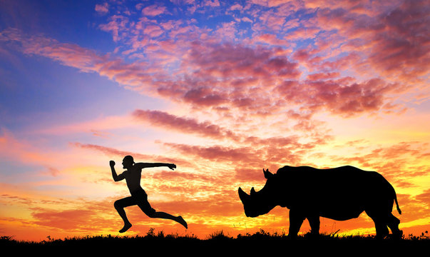 Man running away from Rhino