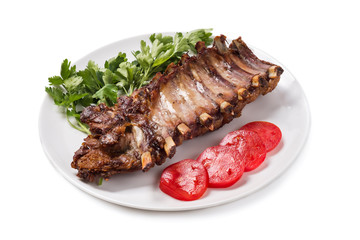 Baked pork ribs with vegetables isolated on white background