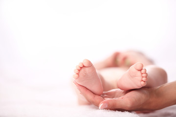 newborn baby feet on female hands 