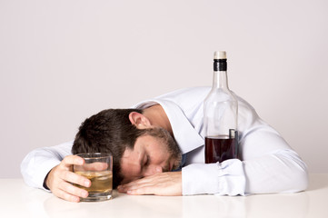 drunk wasted Business man sleeping on desk with whiskey bottle