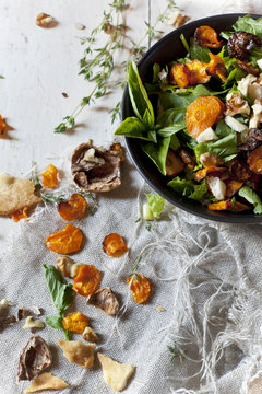 salad with rocket, carrots chips, walnuts and seed in bowl