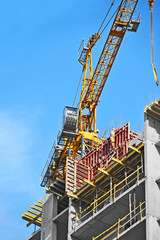 Crane and building construction site against blue sky