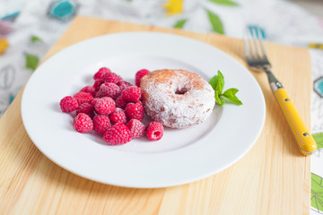 Breakfast. Donut with raspberries on plate