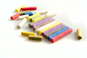color pieces of chalk on a white background