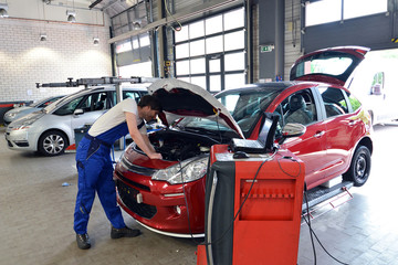 Obraz premium KFZ Mechaniker prüft Motor // mechanic in car workshop
