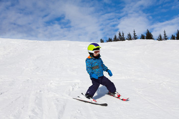 Fototapeta na wymiar Boy in ski mask skiing on snow downhill