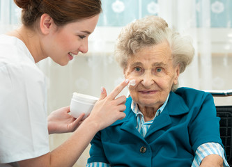Elderly woman is assisted by nurse at home
