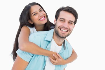 Fototapeta premium Happy casual man giving pretty girlfriend piggy back