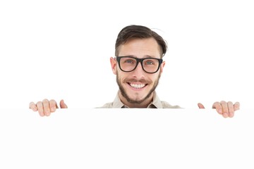Geeky hipster showing poster smiling at camera