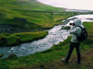 Photographer shooting over the kirkjufell river, west iceland