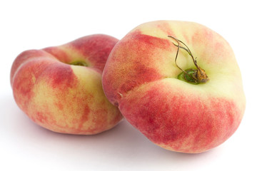 Group of ripe flat peaches on white
