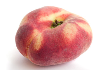 Single flat peach on white with selective focus.