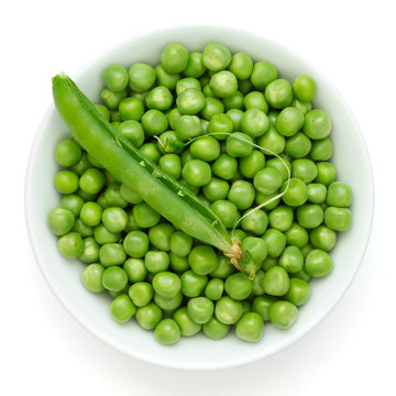 Fresh garden peas in a ceramic dish shot from above.With pod.
