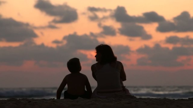 mother with her baby during sunset on the sea