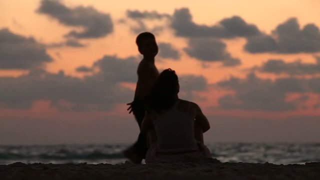 mother with her baby during sunset on the sea