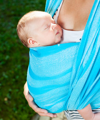 Woman with newborn baby in sling