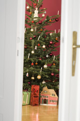 Naklejka premium Zobacz przez otwarte drzwi na choinkę i prezenty