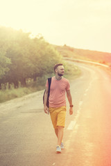 Handsome man walking on a countryside road. Retro vintage instag
