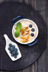 Oatmeal  porridge with raisins, nuts and blueberries. Breakfast