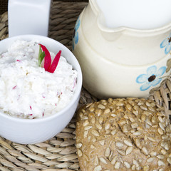 cottage cheese with radish, milk jug and wholemeal bun
