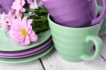 Obraz na płótnie Canvas Cups and saucers with flowers on wooden background