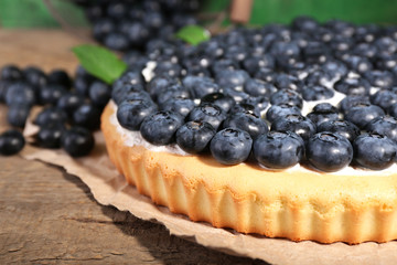 Tasty homemade pie with blueberries on wooden table