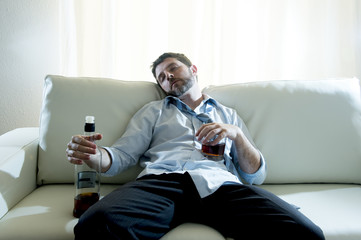 alcoholic Businessman in shirt and tie sleeping drunk on couch