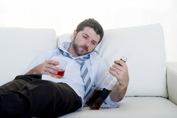 alcoholic Businessman in shirt and tie drunk on couch