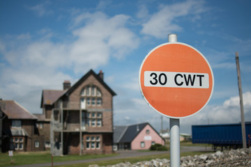 A red, circular road sign indicating a maximum weight of 30 CWT