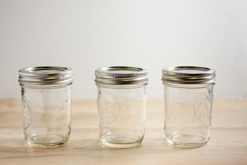 Empty canning jars on a wooden tabletop.