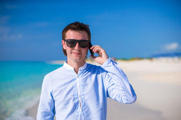 Young man with laptop and phone on the background of turquoise