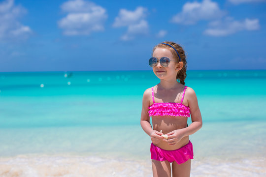 Cute little girl in sunglasses at beach during summer vacation