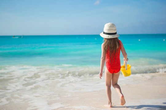 Happy little girl playing at beach during caribbean vacation